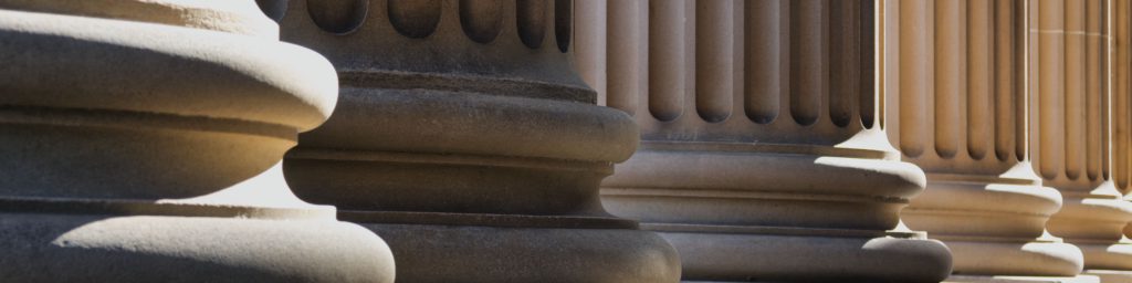Series of sandstone columns with biography and history in type over